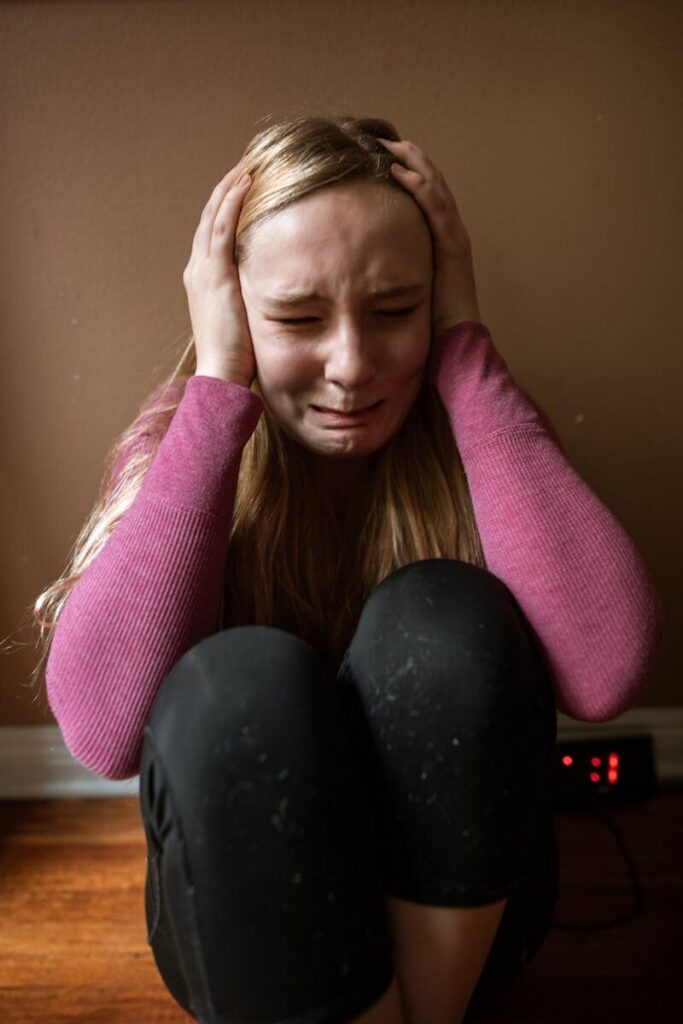 Woman expressing distress and emotion indoors, showing anxiety and fear.